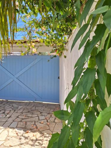 a blue gate in a fence with green leaves at El refugio in Búzios
