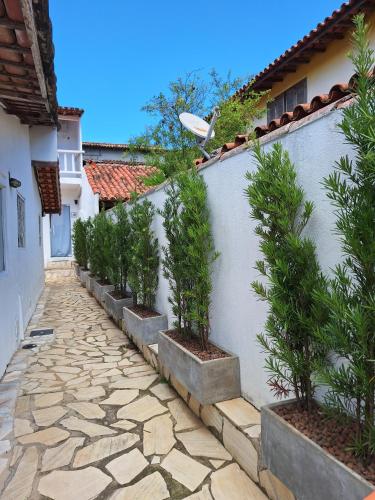 a stone walkway with potted plants on the side of a building at El refugio in Búzios
