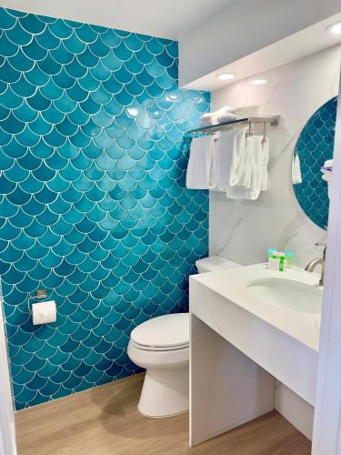 a bathroom with a toilet and a blue wall at Ragged Edge Resort & Marina in Islamorada