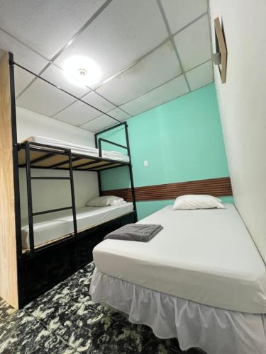 a bedroom with two bunk beds and a blue wall at Hostal Villa Marta in Santa Ana