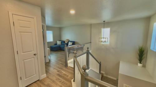 a room with a staircase and a person sitting on a couch at Modern Luxury Haven in Colorado Springs