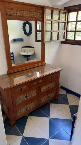 a bathroom with a dresser with a mirror and a sink at Hotel Paraiso Escondido in Puerto Escondido