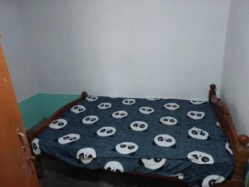 a bed with a blanket with panda faces on it at Alumpara House - Home Stay in Palakkad