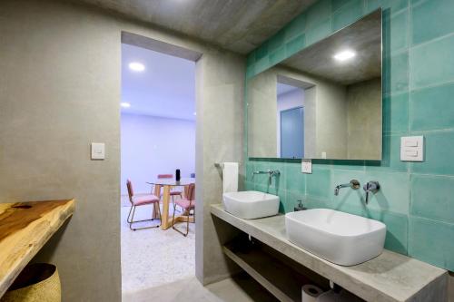 a bathroom with a sink and a mirror and a table at MATAMOROS 2 · Refugio Céntrico con Piscina in Oaxaca City
