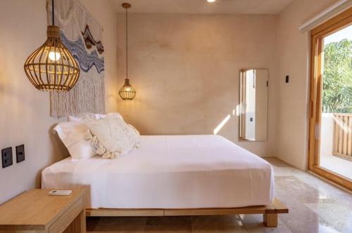 a bedroom with a large white bed and a table at PH POINTE · Luxury Penthouse with Pool in Brisas de Zicatela