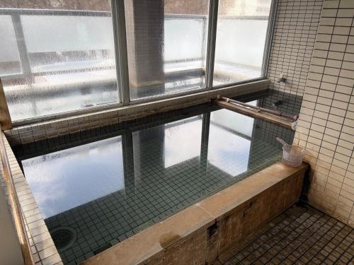 a bathroom with a window and a bath tub at フューデイズコンドミニアム定山渓102号室 in Jozankei