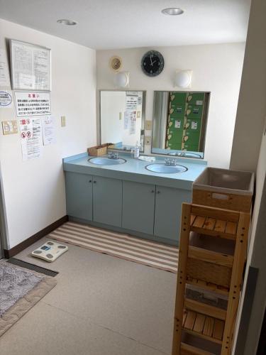 a bathroom with two sinks and a mirror at フューデイズコンドミニアム定山渓102号室 in Jozankei
