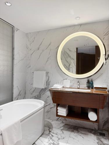 a bathroom with a tub and a sink and a mirror at Crowne Plaza Macau by IHG in Macau