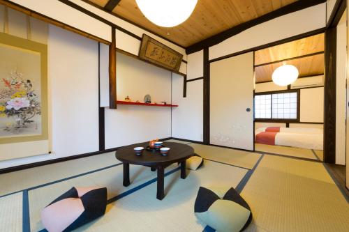 a room with a table and two chairs and a bed at Kyotoya Tsuki no Yu Bettei in Kyoto