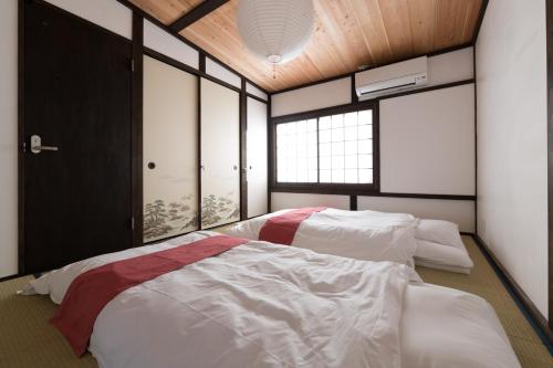 a bedroom with two beds and a window at Kyotoya Tsuki no Yu Bettei in Kyoto