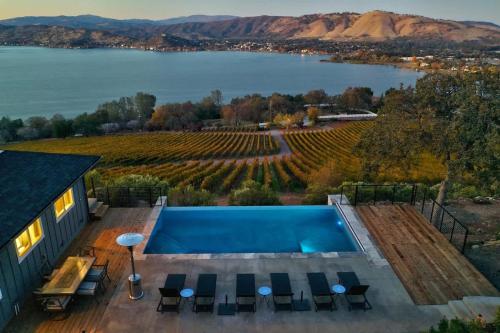a house with a swimming pool and a view of a lake at Vineyard Setting With 180 Panoramic Lake Views in Lower Lake