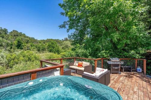 a hot tub on a deck with a grill at River View Lodge - Hot Tub And Tastings Included in Healdsburg