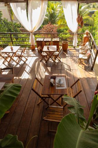 a wooden deck with chairs and tables on it at Pousada Unaí - Casa Flor in Fernando de Noronha