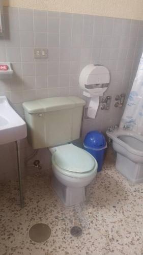 a bathroom with a white toilet and a sink at HOTEL Nevada Palace in Mérida
