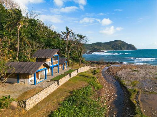 a small house on the beach next to the ocean at L'Astrolabe - Riverside Bungalow with Sea View in Baras