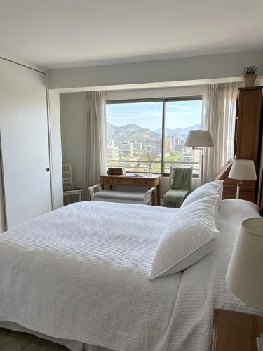 a bedroom with a large white bed and a window at Las Condes familiar Deluxe in Santiago