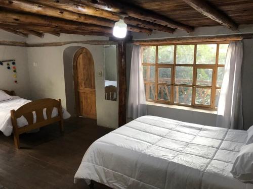 a bedroom with a large bed and a window at Los Laureles Sacred valley in Urubamba