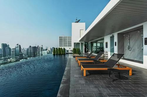 a row of chairs on the side of a building with water at Siamese Residence Sukhumvit 42 Bangkok in Bangkok