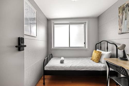 a small bedroom with a bed and a window at Light & Simple Single Room - Peakhurst Area - Shared Bathroom in Peakhurst