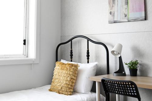 a bedroom with a bed and a table with a lamp at Light & Simple Single Room - Peakhurst Area - Shared Bathroom in Peakhurst