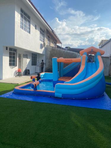 a large inflatable water slide in a yard at Anggun's palace in Pasir Gudang