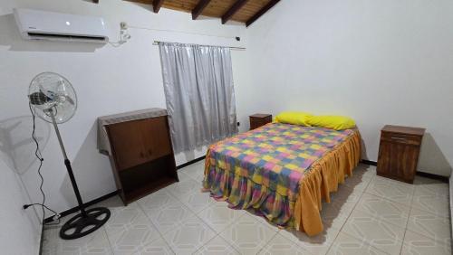 a bedroom with a bed and a floor fan at Departamentos Hernan in Apóstoles