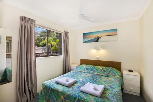 a bedroom with a bed and a window at Allamanda 37 in Long Jetty