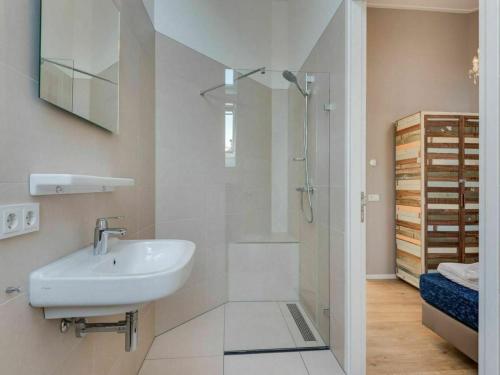 a white bathroom with a sink and a shower at Achterhoek Villa with Heated Pool in Aalten