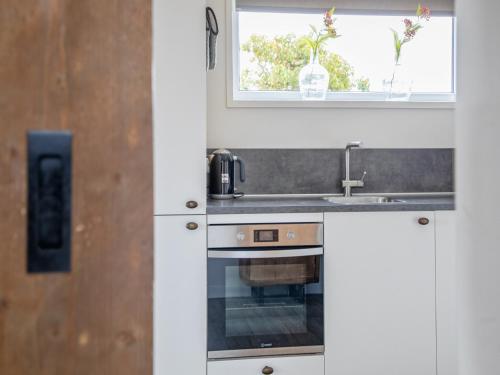 a kitchen with a sink and a stove at Stylish Texel Escape with Spa in Den Burg