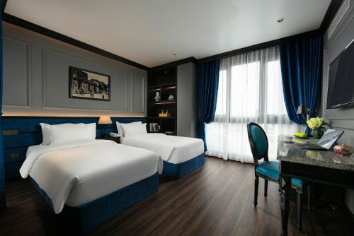 a bedroom with two beds and a desk and a piano at Casa Dos Príncipes Hotel & Spa in Hanoi