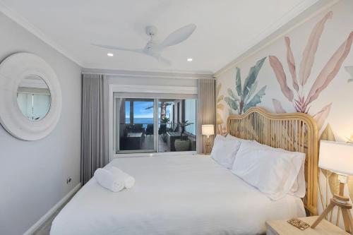 a bedroom with a large white bed and a window at Ocean Pines Apartment 5 in The Entrance