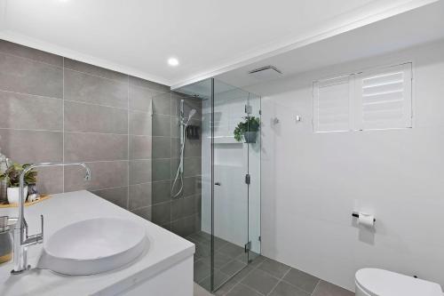 a bathroom with a shower and a toilet and a sink at Ocean Pines Apartment 5 in The Entrance