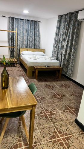 a bedroom with a bed and a desk and a table at Oasis Town in Carenero