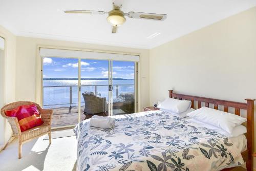 a bedroom with a bed and a view of the ocean at Bluewater at Mannering Park in Mannering Park
