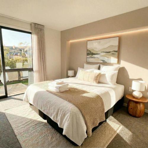 a bedroom with a large bed and a large window at Mount Pisa View Stay - Barnd new holiday home in Cromwell