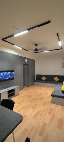 a large room with a wooden floor and a clock at The Loft - Male Only in Chennai