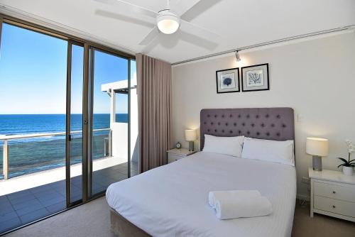 a bedroom with a bed with a view of the ocean at Beachfront on Werrina in Blue Bay 