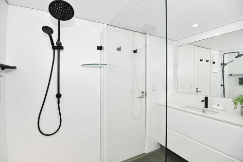 a shower in a white bathroom with a glass wall at Beachfront on Werrina in Blue Bay 