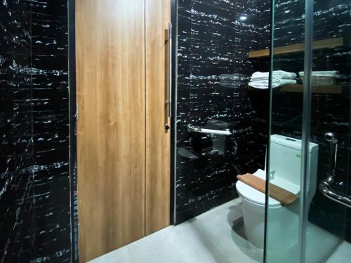 a bathroom with a toilet and a glass wall at RedDoorz Plus at edOtel Malang in Betek