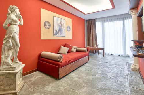 a red room with a bed and a statue at Hotel del Sole in Pompei