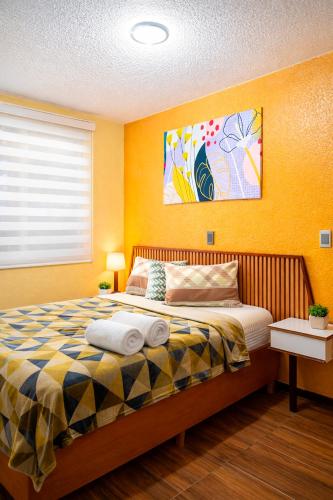 a bedroom with a bed with yellow walls at Hotel Los Diamantes Orizaba in Orizaba