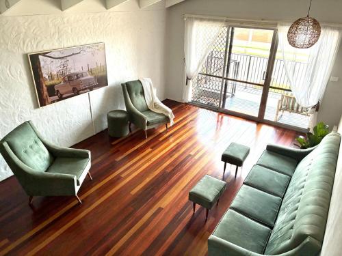 a living room with a couch and two chairs at The Sage Sea Shack in Caloundra