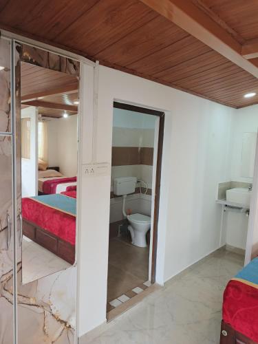 ein Zimmer mit zwei Betten und einem Badezimmer mit Toilette in der Unterkunft Blackcherry Munnar in Munnar