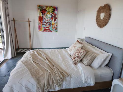 a bedroom with a bed with white sheets and pillows at Ocean View Oasis in Cannonvale