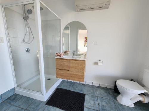 a bathroom with a shower and a toilet and a sink at Ocean View Oasis in Cannonvale