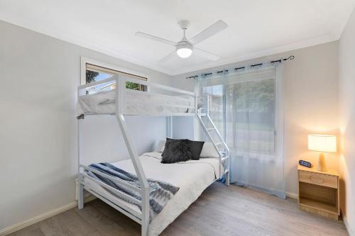 a bedroom with a bunk bed and a window at Bonnieview House in Shelly Beach