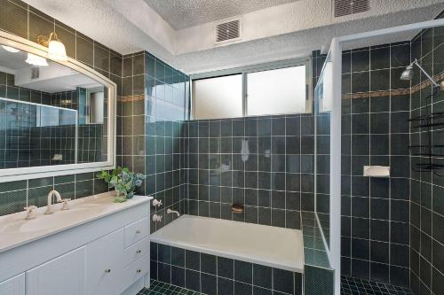 a bathroom with a tub and a sink and a mirror at Regency Court 4 in The Entrance