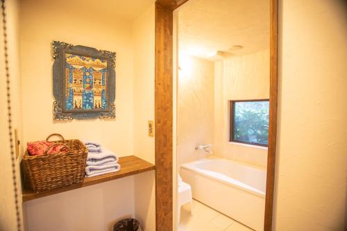 a bathroom with a tub and a sink and a mirror at Estivant Club in Tsumagoi