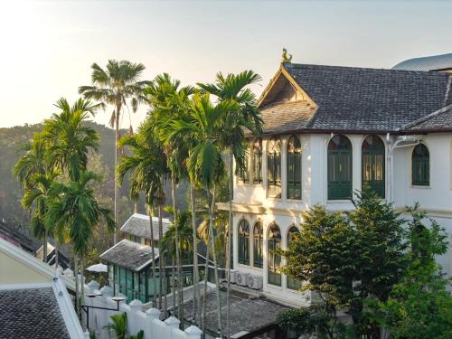 an image of a house with palm trees at Cheva Gallery Boutique Hotel in Chiang Mai