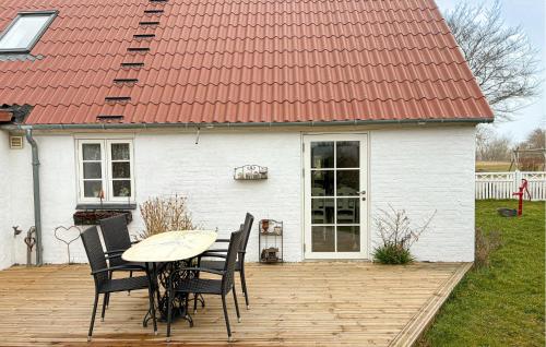 a table and chairs on a wooden deck in front of a house at 2 Bedroom Nice Home In Gedser in Gedser